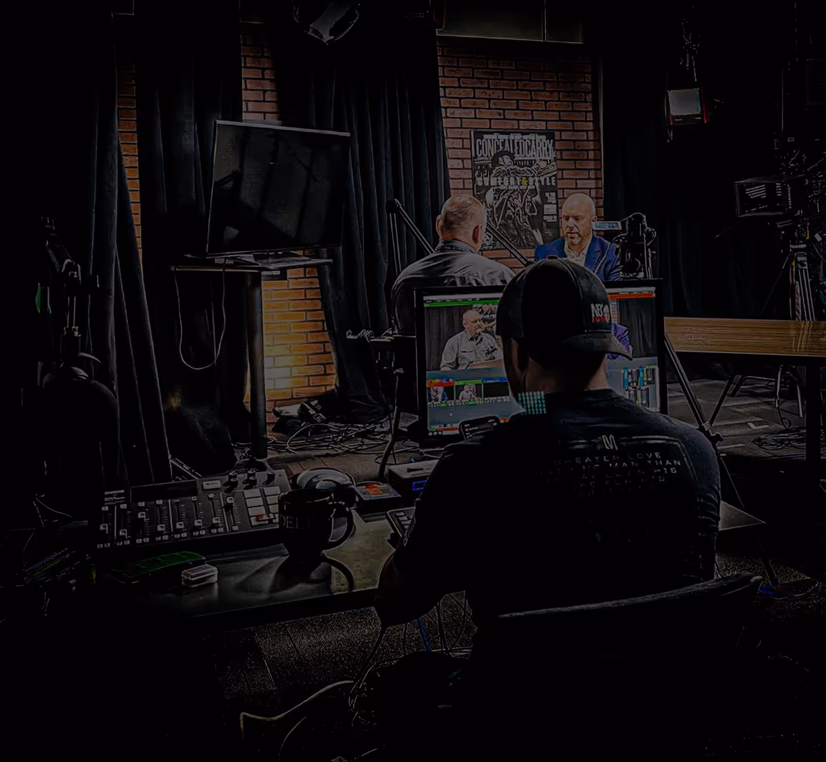 Live broadcast control room — multi-cam switcher, monitor wall, on-air talent.