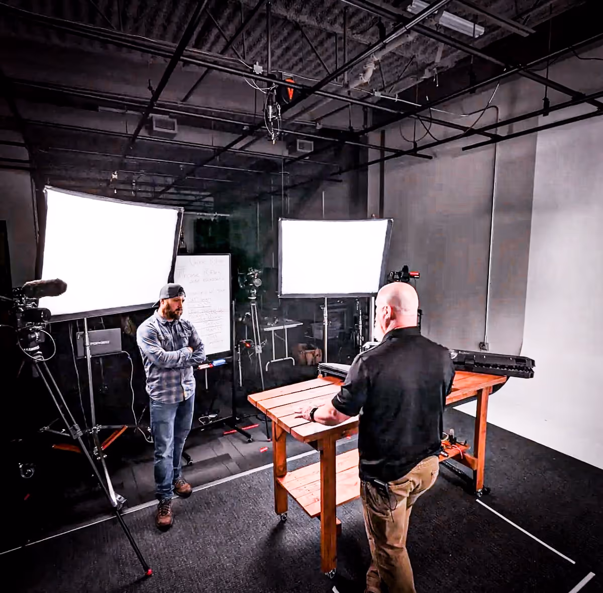Two-camera studio shoot with key lights and dolly track.